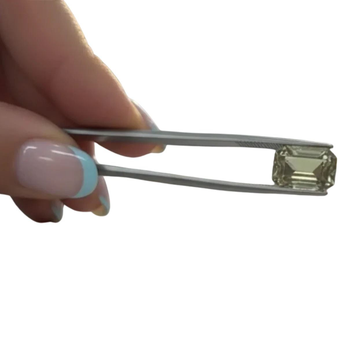 A gemstone held in tweezers
